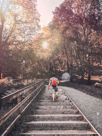 Man walking on railroad track against sky