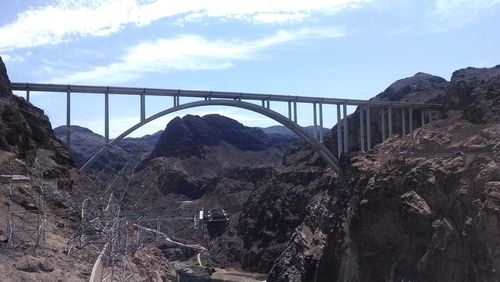 Bridge over river against cloudy sky