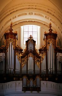 Low angle view of pipe organ in old church