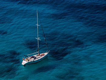 High angle view of sail boat in calm blue sea