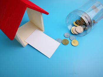 High angle view of coins on table against blue background