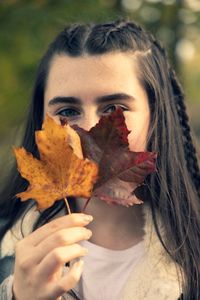 Portrait of woman holding autumn leaf