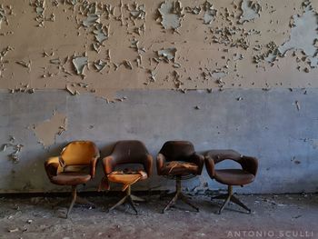 Empty chairs against wall