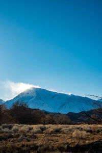 Scenic view of snowcapped mountains against blue sky