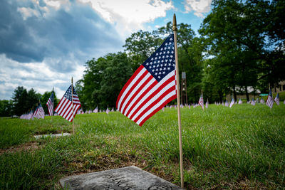 Red flag in cemetery against sky