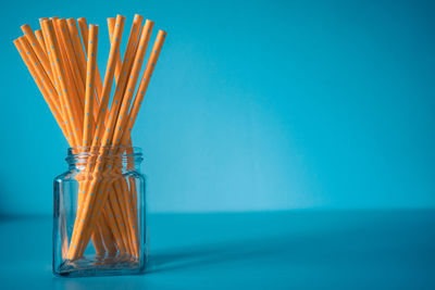 Close-up of glass jar on table against blue background