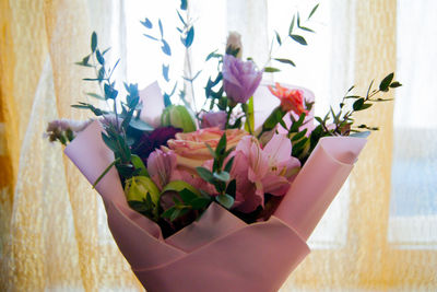 Close-up of hand holding purple flower pot