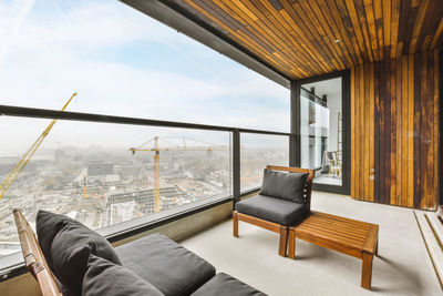 Interior of spacious balcony with soft sofas in new flat in apartment building