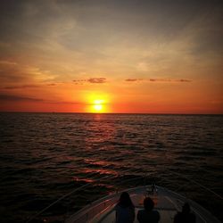 Silhouette man standing on sea against sky during sunset