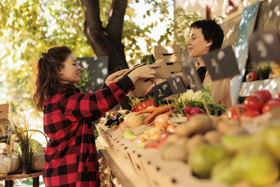 Side view of young woman preparing food at market