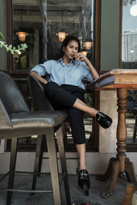 Young woman sitting on chair at table