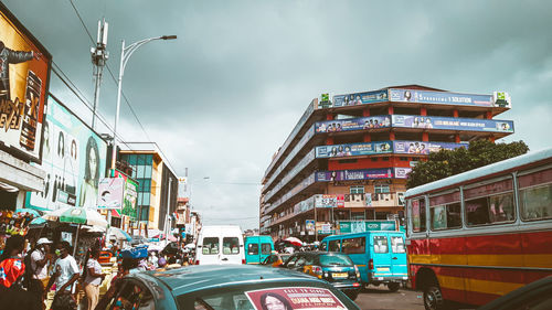 Cars on street in city against sky