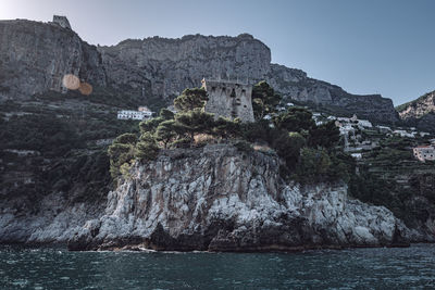 Coastal tower on the amalfi coast with the lattari mountains behind it