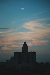 Silhouette buildings against sky during sunset