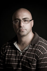 Portrait of young man against black background