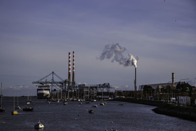 Boats in harbor against sky