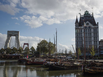 Boats moored in river with buildings in background