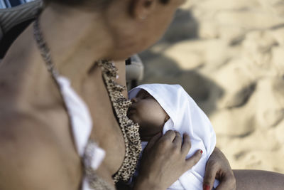 Midsection of mother with baby outdoors