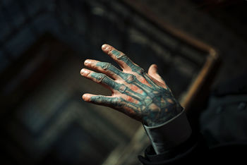 Cropped hand of young man with tattoo over spiral staircase
