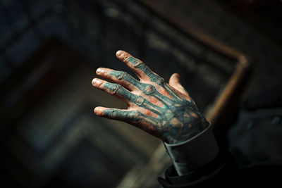 Cropped hand of young man with tattoo over spiral staircase