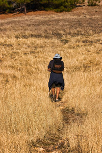 Rear view of man walking on field