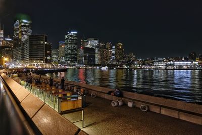 Illuminated buildings by swimming pool at night