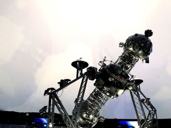 Low angle view of cranes against sky