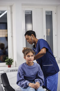 Doctor examining girl patient with stethoscope