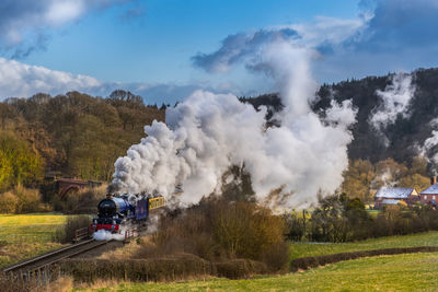 High angle view of steam train moving amidst landscape against sky