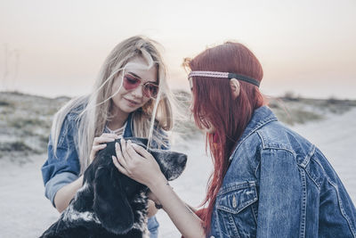 Portrait of smiling young woman wearing sunglasses while standing against sky