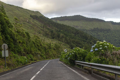 Road leading towards mountains against sky