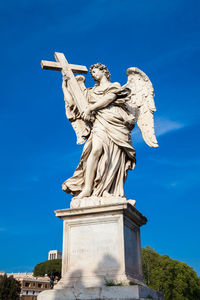 Low angle view of statue against blue sky