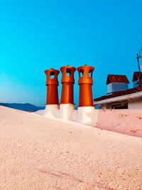 Fire hydrant on beach against clear blue sky