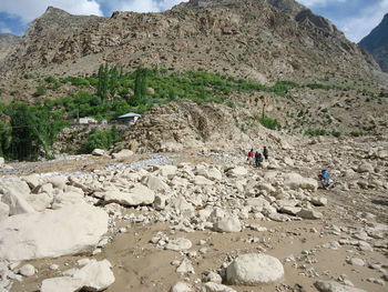 People on rock by mountain