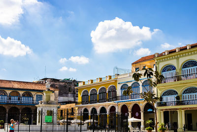 Buildings in city against cloudy sky