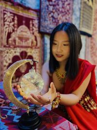 Portrait of smiling young woman blowing bubbles at home