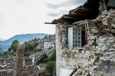 Old building by mountains against sky