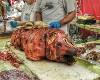 Midsection of man eating food at market