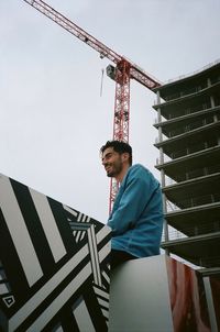 Low angle view of man standing on staircase against sky