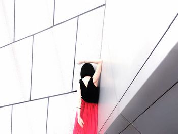 Rear view of woman standing against wall