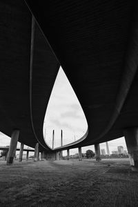Low angle view of bridge against cloudy sky
