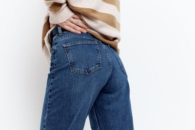 Low section of woman standing against white background