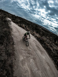 Bicycle on road by sea against sky