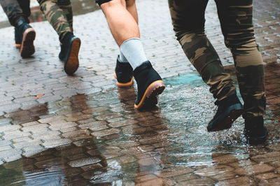 Low section of men walking on wet walkway