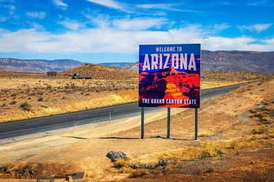 Information sign on road against sky