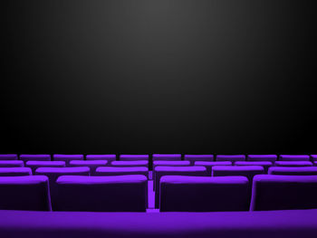 Empty chairs against black background