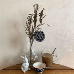 Plant in vase on table against wall at home