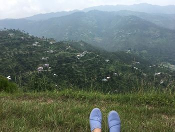 Low section of person on field against mountains