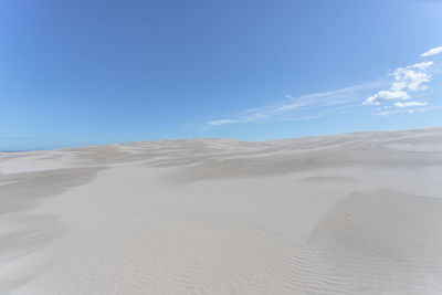 Scenic view of desert against blue sky