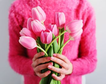 Close-up of woman holding pink flower